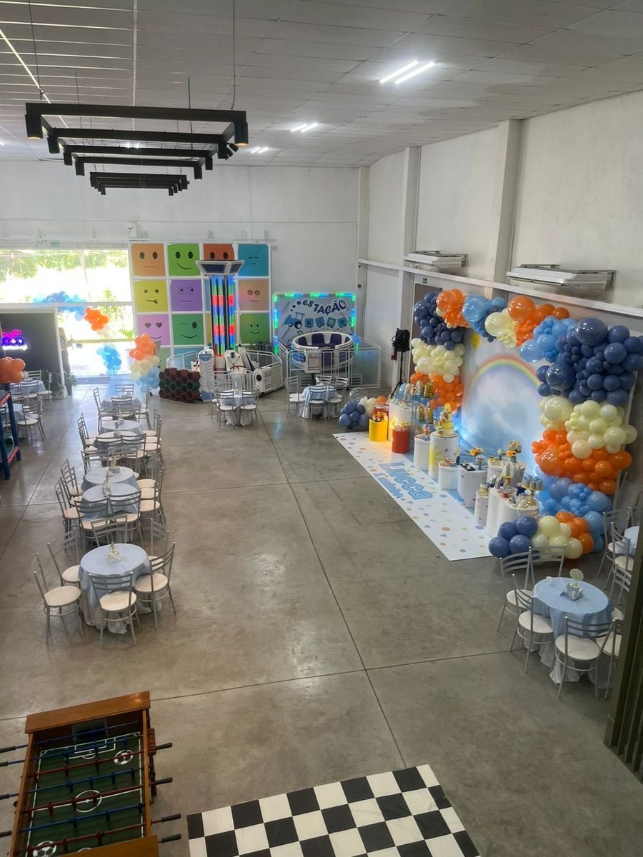 Salão com mesas, brinquedos e área kids