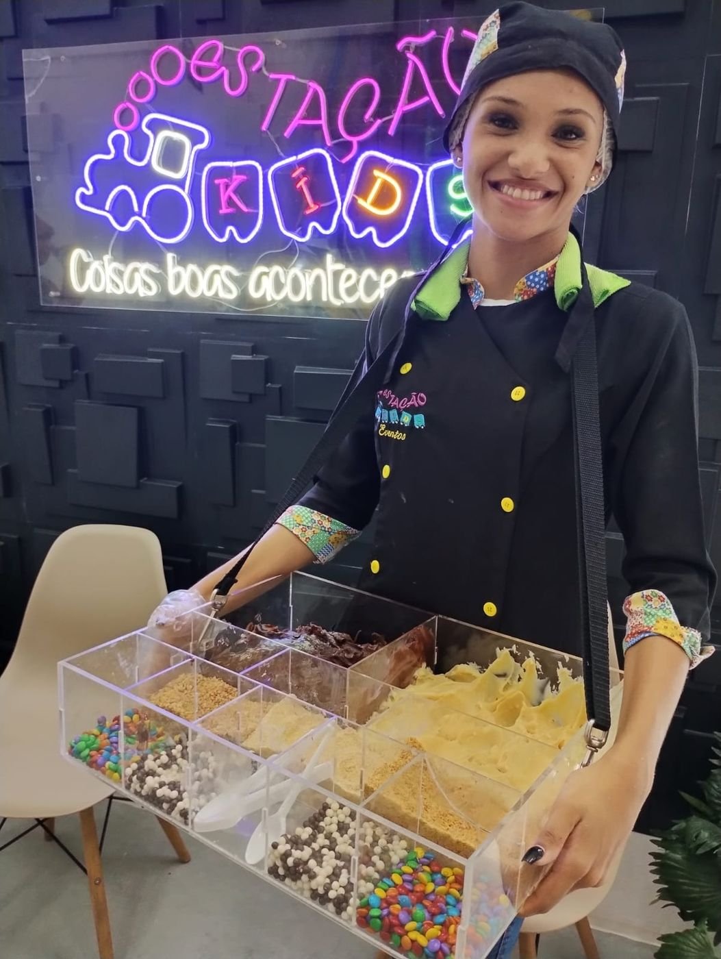 Tabuleiro de brigadeiro com confeitos servido por uma atendente